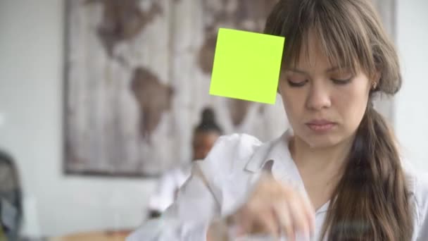 Femme d'affaires en utilisant la stratégie de résolution de notes collantes sur tableau blanc en verre — Video