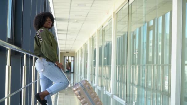 Afrikansk amerikansk flicka väntar på ombordstigning och avgång på flygplatsen — Stockvideo
