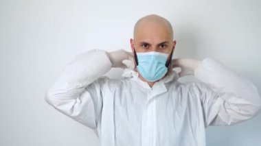 Doktor koruyucu giysi giyer. Ofis binasında çalışan koruyucu giyimli ve maskeli bir virüs uzmanı.