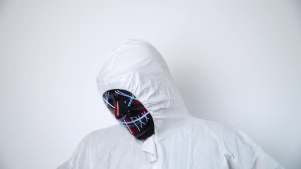 Een man met een zwart masker en beschermende overall die naar de camera kijkt. — Stockvideo