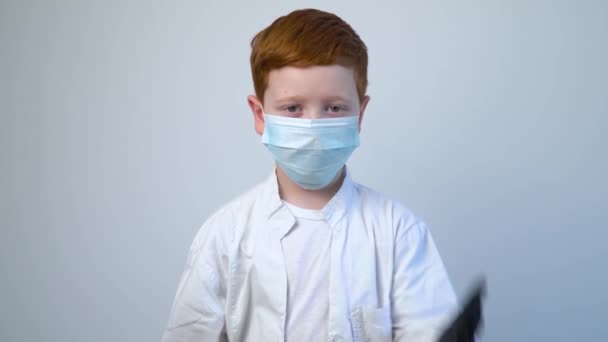 Κοντινό πλάνο του καυκάσιου νεαρού γιατρού με προστατευτική μάσκα. Ο γιατρός βάζει μαύρα προστατευτικά γάντια. Προστασία Covid-19 — Αρχείο Βίντεο