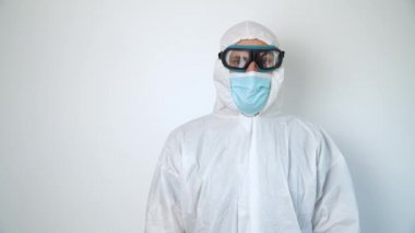 Koruyucu giysi, gözlük ve maske takan bir virüs uzmanı portresi.