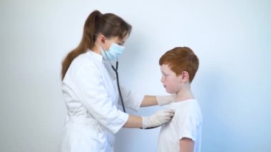 Stetoskop kullanan kadın doktor çocuk doktoru, hastaneye yaptığı tıbbi ziyarette hasta bir çocuğun akciğerlerini ve kalbini dinliyor, çocuk sağlığı konsepti. Covid-19 'u tespit et.