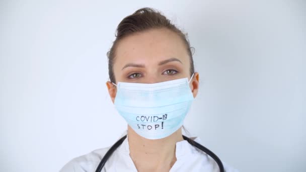 Крупный план кавказского врача со стетоскопом в защитной маске. Защита Covid-19. Остановить коронавирус — стоковое видео