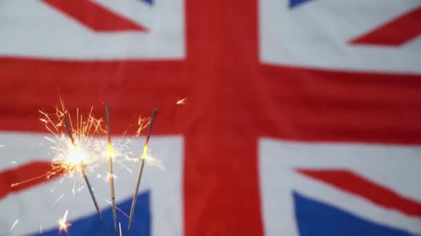 Három csillagszóró brit zászlóval a háttérben. Ünnepeljük az új évet és a karácsonyt — Stock videók