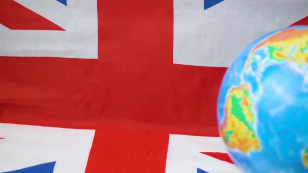 Globus mit britischer Flagge im Hintergrund. Britisches Commonwealth — Stockvideo