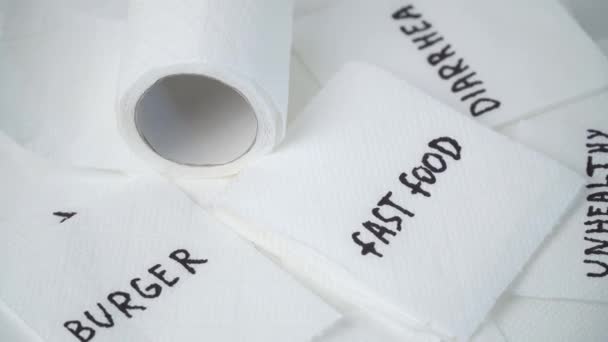 Toiletpapier met tekst fast food. Begrip persoonlijke hygiëne. Ongezond fastfood Concept — Stockvideo