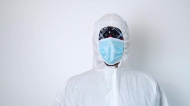 Koruyucu giysili ve siyah maskeli bir virüs uzmanı portresi.