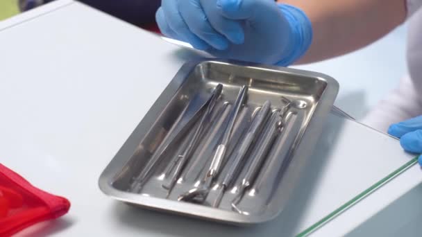 Крупный план женщины-стоматолога, принимающей медицинские инструменты — стоковое видео