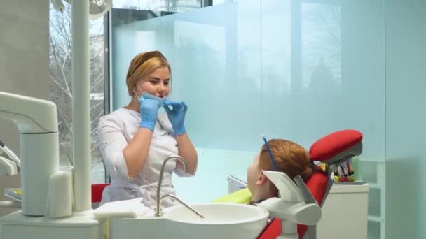 Zahnärztin setzt Schutzmaske auf. Kinderzahnheilkunde — Stockvideo