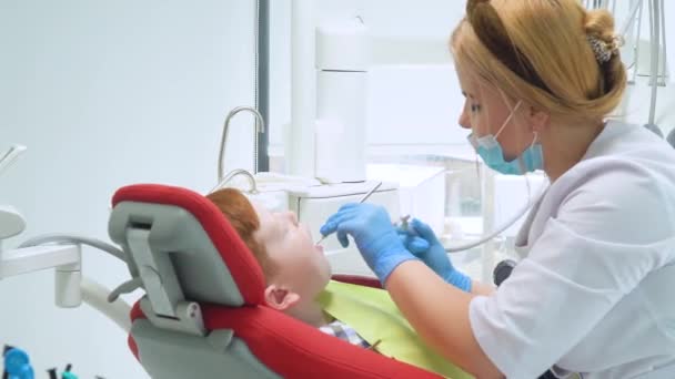 Een kleine jongen met een tandenpoetsbehandeling in de tandheelkunde — Stockvideo