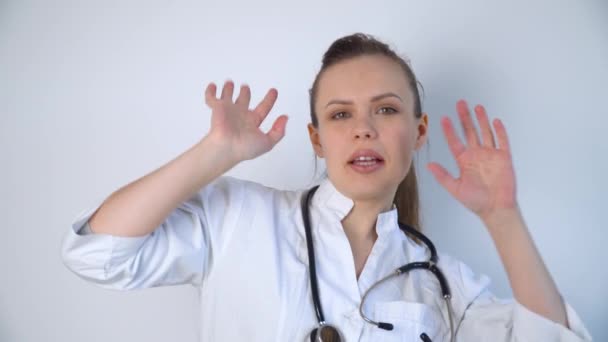 Mulher médica engraçada em um casaco branco com um estetoscópio dançando e celebra a vitória sobre o coronavírus covid-19 em um hospital — Vídeo de Stock