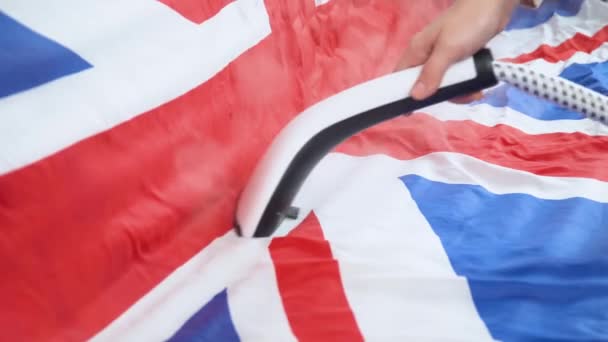 Mujer planchando bandera del Reino Unido con plancha de vapor. Preparación para el cumpleaños oficial de Queens — Vídeo de stock