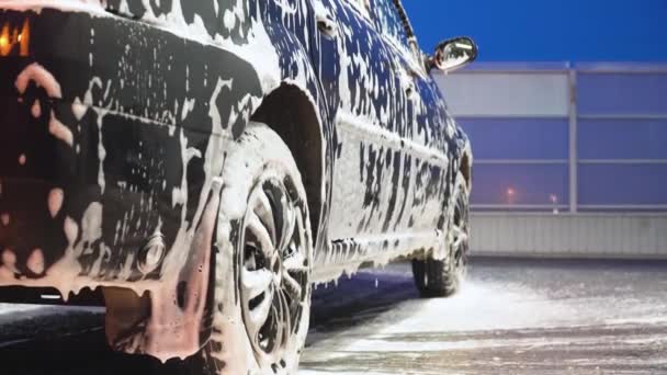 Машина покрыта белой пеной для мытья. Автомойка — стоковое видео