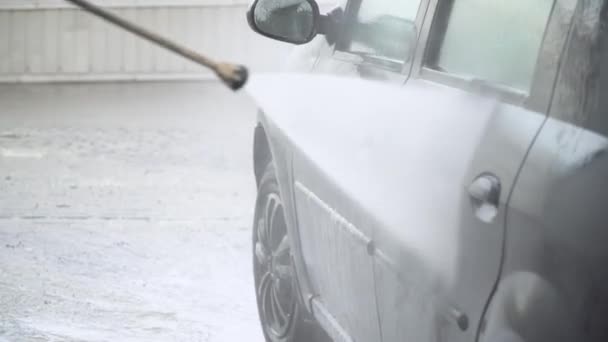 Autómosó önkiszolgáló. Egy férfi nagynyomású berendezéssel mossa a gépet. — Stock videók