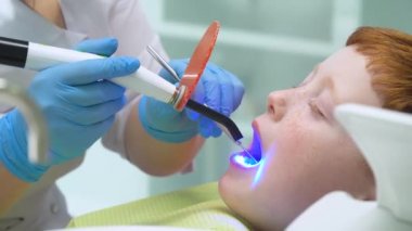 Kadın dişçi iş başında. Diş hekiminin resepsiyonundaki küçük çocuk. Pediatrik dişçilik