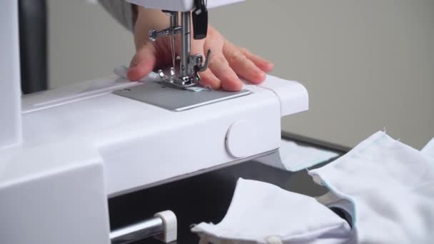 Woman sews a white protective mask. Making cotton fabric medical mask, virus protection — Stock Video