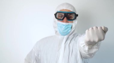 Virologist in protective coverall and mask shows the fuck you middle finger. Fuck coronavirus, covid-19