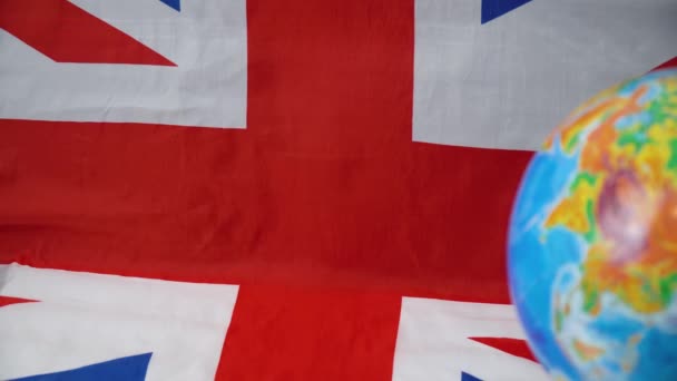Globen med brittisk flagga i bakgrunden. Brittiska samväldet — Stockvideo