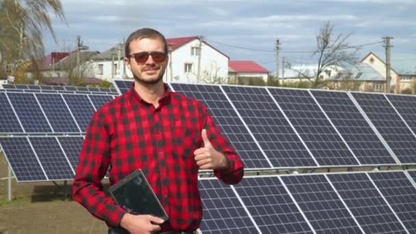Προσωπογραφία ενός νέου μηχανικού στο φόντο ενός σταθμού ηλιακής ενέργειας — Αρχείο Βίντεο