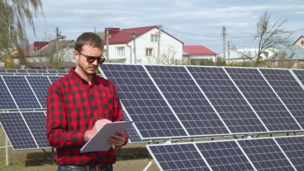 Ingeniero joven exitoso que planea una planta de energía de paneles solares futuristas — Vídeo de stock