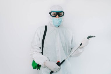Virolog, koronavirüs salgını sırasında koruyucu giysiler giyip portre yapıyor. Klinikte ya da hastanede beyaz arkaplanda takım elbise, maske, eldiven ve gözlük