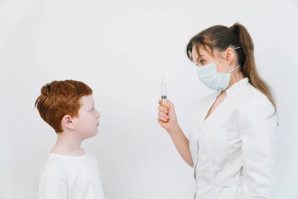 Doctor injecting a child with a vaccination in a small disposable hypodermic syringe, close up of the kids arm and needle — Stock Photo, Image