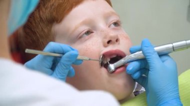 Küçük bir çocuk diş hekimliğinde diş temizliği yaptırıyor. Pediatrik dişçilik