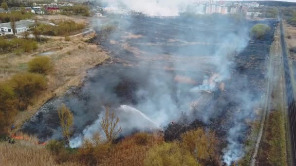 Vue aérienne du pompier dans l'équipement éteindre un incendie de forêt avec un tuyau d'incendie