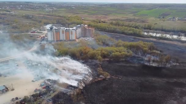 Вид с воздуха на большие облака дыма и огонь по полю. Воздушный беспилотный полет над горящей склоном холма с густым белым дымом сдуло рамку — стоковое видео