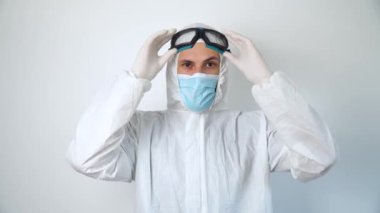 Dezenfektan güvenlik gözlüğü takar. Ofis binasında çalışan koruyucu giyimli ve maskeli bir virüs uzmanı.