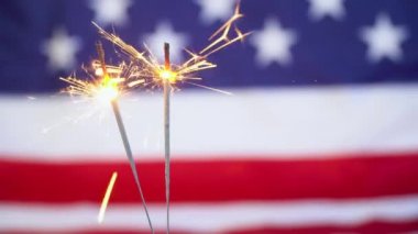 Arka planda ABD bayrağı olan iki maytap. Yeni Yıl ve Noel 'i Kutlamak