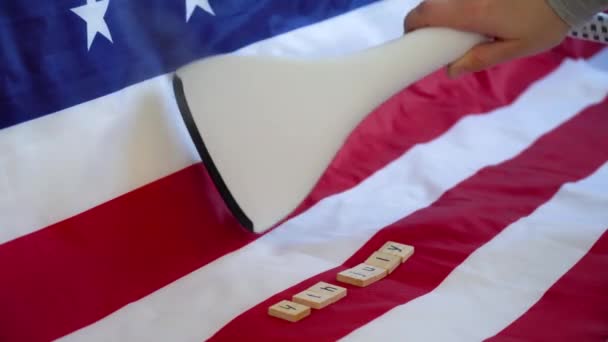 Een vrouw streelt de Amerikaanse vlag met een stoomstrijkijzer. Amerikaanse voorbereidingen voor onafhankelijkheidsdag — Stockvideo