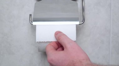 Tuvalet kağıdında mesaj paniği var. Panik halinde bir adam tuvalet kağıdını yırtıyor. Covid-19, hijyen, panik