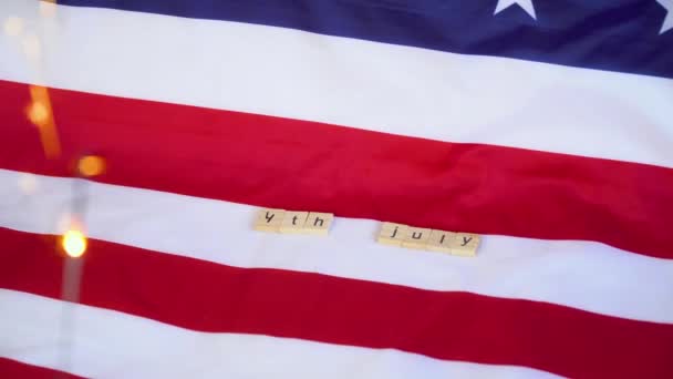 Wir feiern den 4. Juli, den Unabhängigkeitstag. Wunderkerze mit US-Flagge im Hintergrund. — Stockvideo