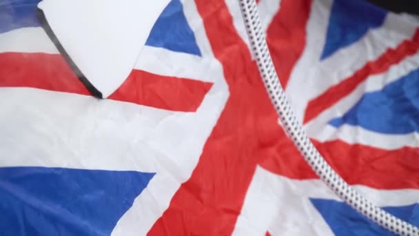 女人用蒸汽熨斗熨烫英国国旗.十一.国定假日的筹备工作 — 图库视频影像