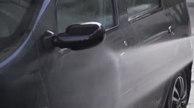 Oto yıkamada araba yıkayan bir adam. Araba yıkama servisi.