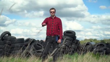 Çöp tekerleği çöplüğünde duran bir aktivist. Kirliliği Durdur