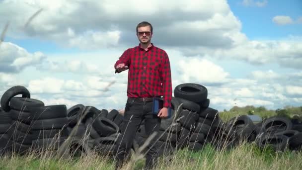 Man activist bij vuilnisbandendump. Verontreiniging stoppen — Stockvideo