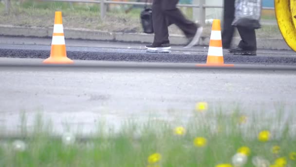 Rouleau de route jaune roule sur une route tout en posant l'asphalte. Construction d'une nouvelle route — Video