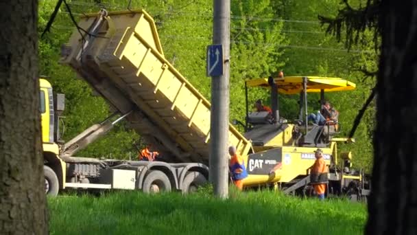 Ternopil, Ukraine, Mai 2020: Straßenarbeiter reparieren die Straße während des Straßenverkehrs mit Straßengeräten. Straßenbauarbeiten — Stockvideo