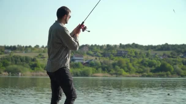 Rybář hodil rybářský prut do jezera nebo říční vody. Rybaření na jezeře — Stock video