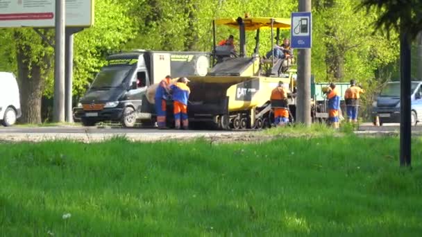 Ternopil, Ukrajna, 2020. május: Közúti munkások aszfaltot fektetnek. Útépítés. A munkahelyet elkerítik a táblák. — Stock videók