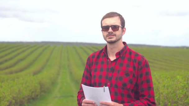 Close up portrait of smiling man farmer standing in tea field and looking at the camera — Stock Video