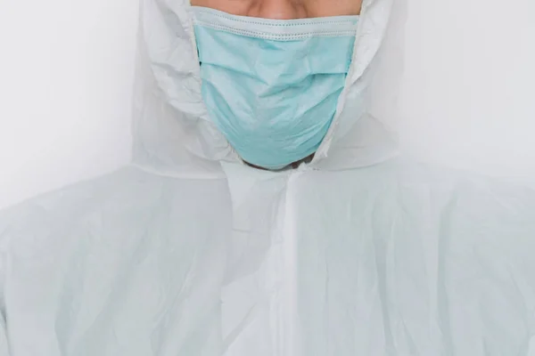 Virologista está tecendo em roupas protetoras durante a pandemia de coronavírus, retrato. Terno, máscara, luvas e óculos em fundo branco na clínica ou hospital — Fotografia de Stock