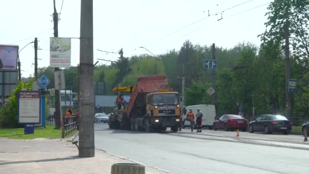 Ternopil, Ukraina, maj 2020: Vägarbetare reparerar vägen samtidigt som vägtrafiken med hjälp av vägutrustning — Stockvideo