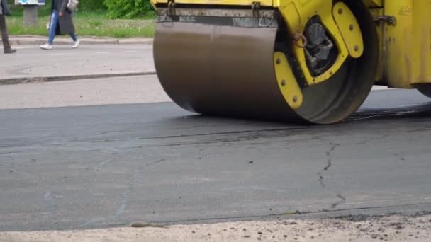 Rouleau de route jaune roule sur une route tout en posant l'asphalte — Video