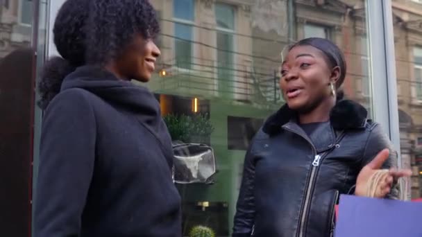 Deux belles filles afro-américaines s'amusent à marcher dans la rue avec leurs achats après avoir fait du shopping — Video