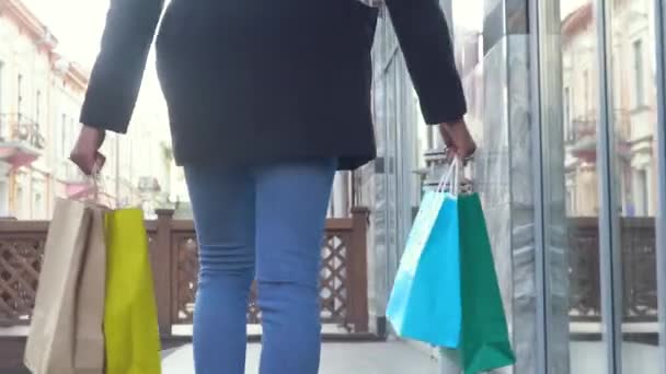 Fille africaine avec des sacs à provisions marchant dans une ville. Sac à provisions — Video