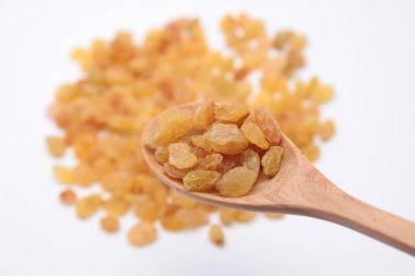 Tahta kaşıkla blury yığın'ın arka plan üzerinde sarı rasins.